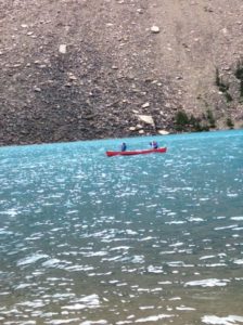 2 people paddling a canoe on a lake